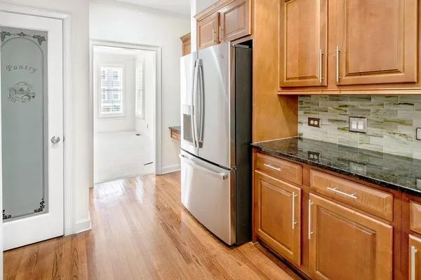 a kitchen with granite countertop a refrigerator and a sink