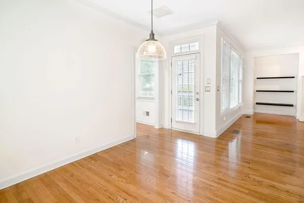 a view of a room with wooden floor and entryway
