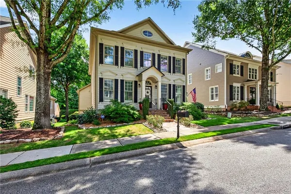 a front view of a house with a yard and tree s