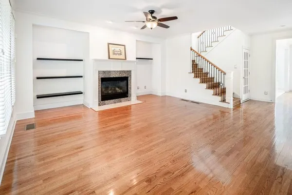 a view of a livingroom with wooden floor and a fireplace