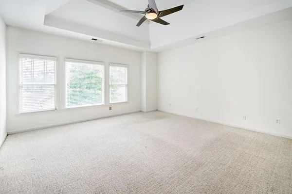 an empty room with a window and a fan