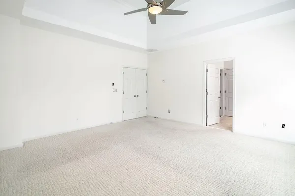 an empty room with a ceiling fan and a window