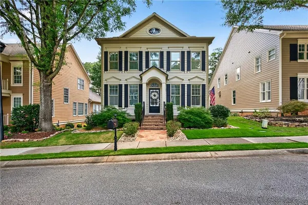 a front view of a house with a yard and potted plants