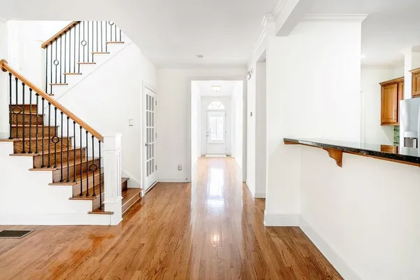 a view of hallway with wooden floor and stairs