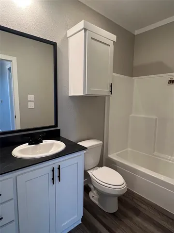 a bathroom with a granite countertop toilet sink and mirror