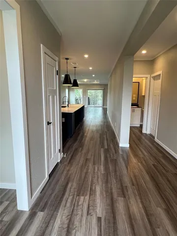 a view of a hallway with wooden floor and staircase