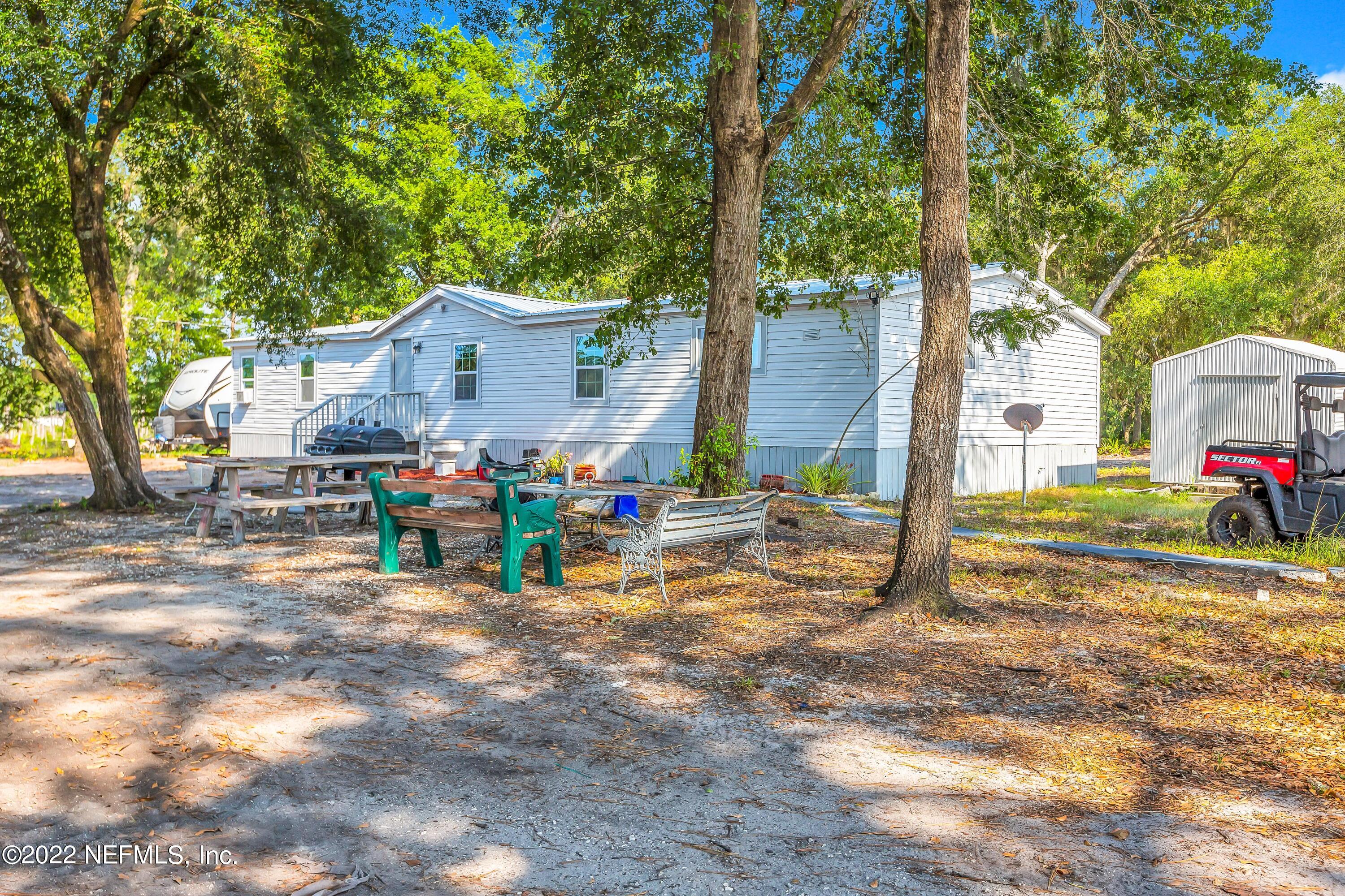 8049 Blazing Star Road Melrose, FL 32666 - Photo 5 of 39 a view of a house with a backyard and a tree