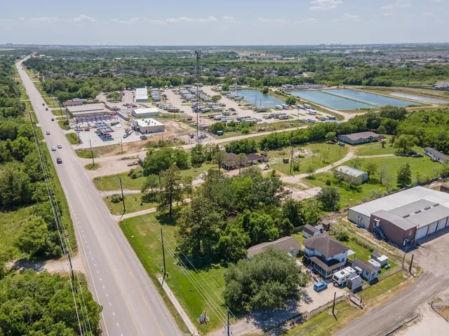 an aerial view of residential houses with outdoor space and trees