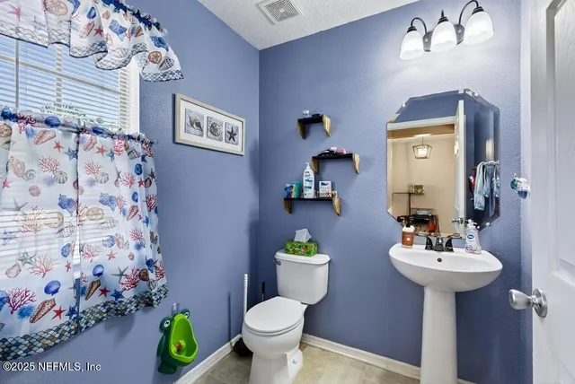a bathroom with a sink toilet and a mirror
