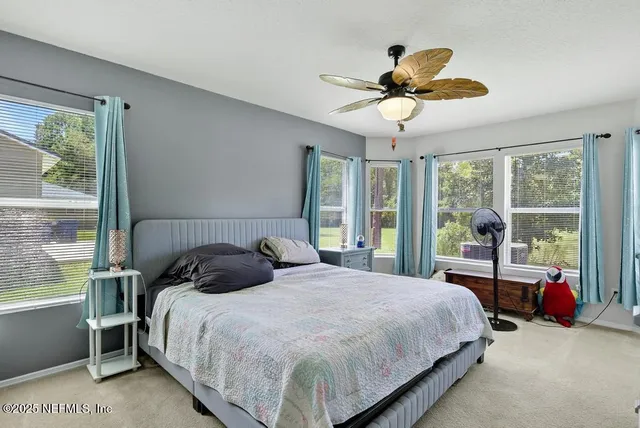 a bedroom with a bed and a large window