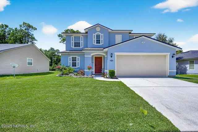 a front view of a house with a garden and yard