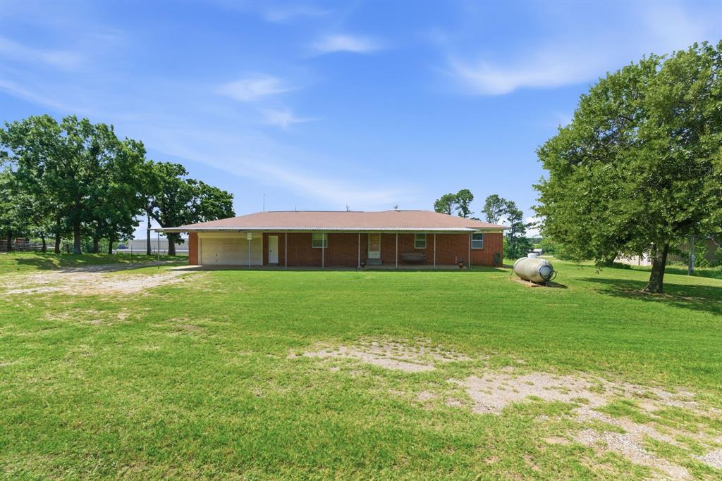 3523 East Highway 199 Springtown, TX 76082 - Photo 26 of 40 Brick exterior home with a covered front porch, an attached carport, and mature trees