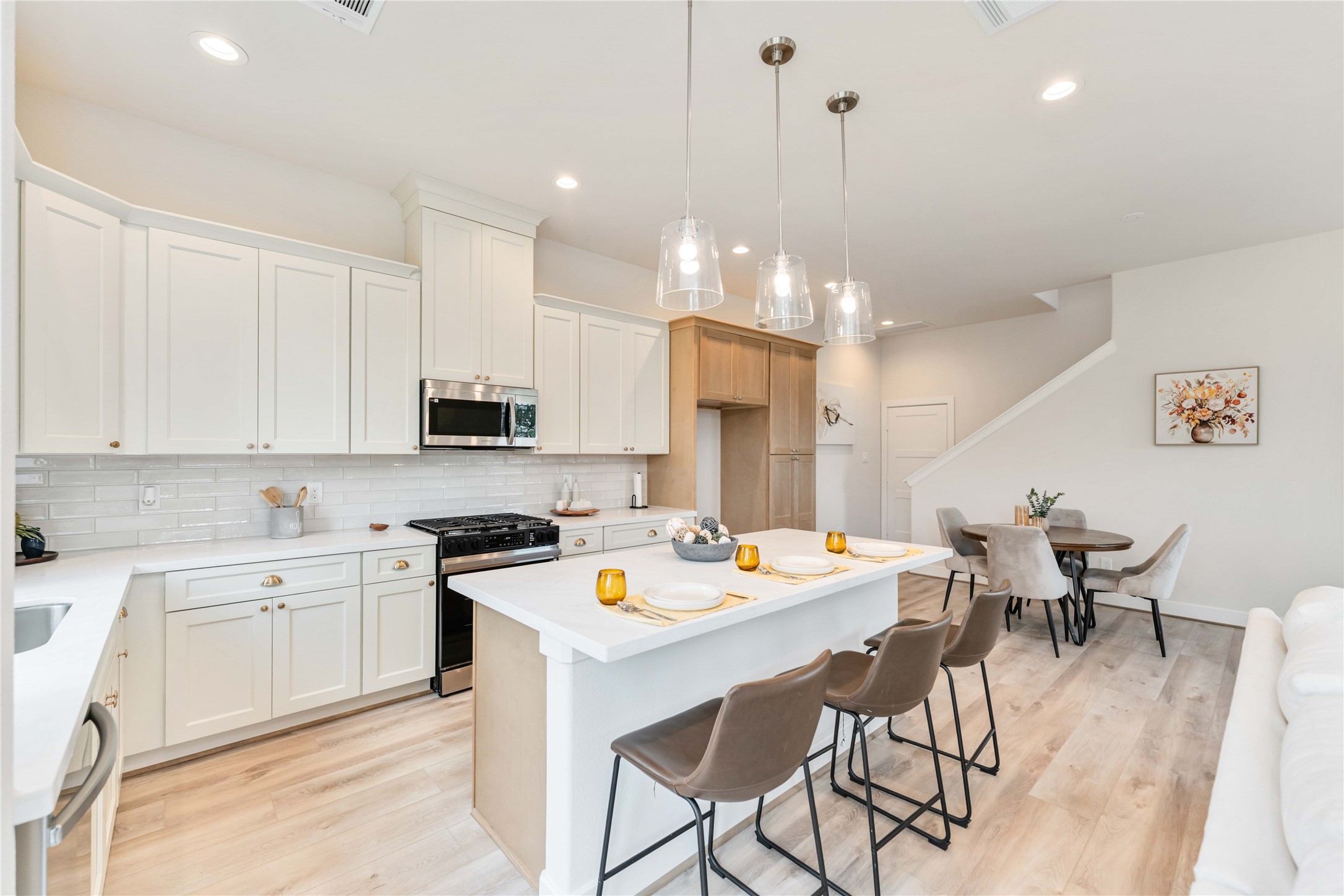 11108 Bauman Road Houston, TX 77076 - Photo 6 of 25 a kitchen with a dining table chairs and white cabinets
