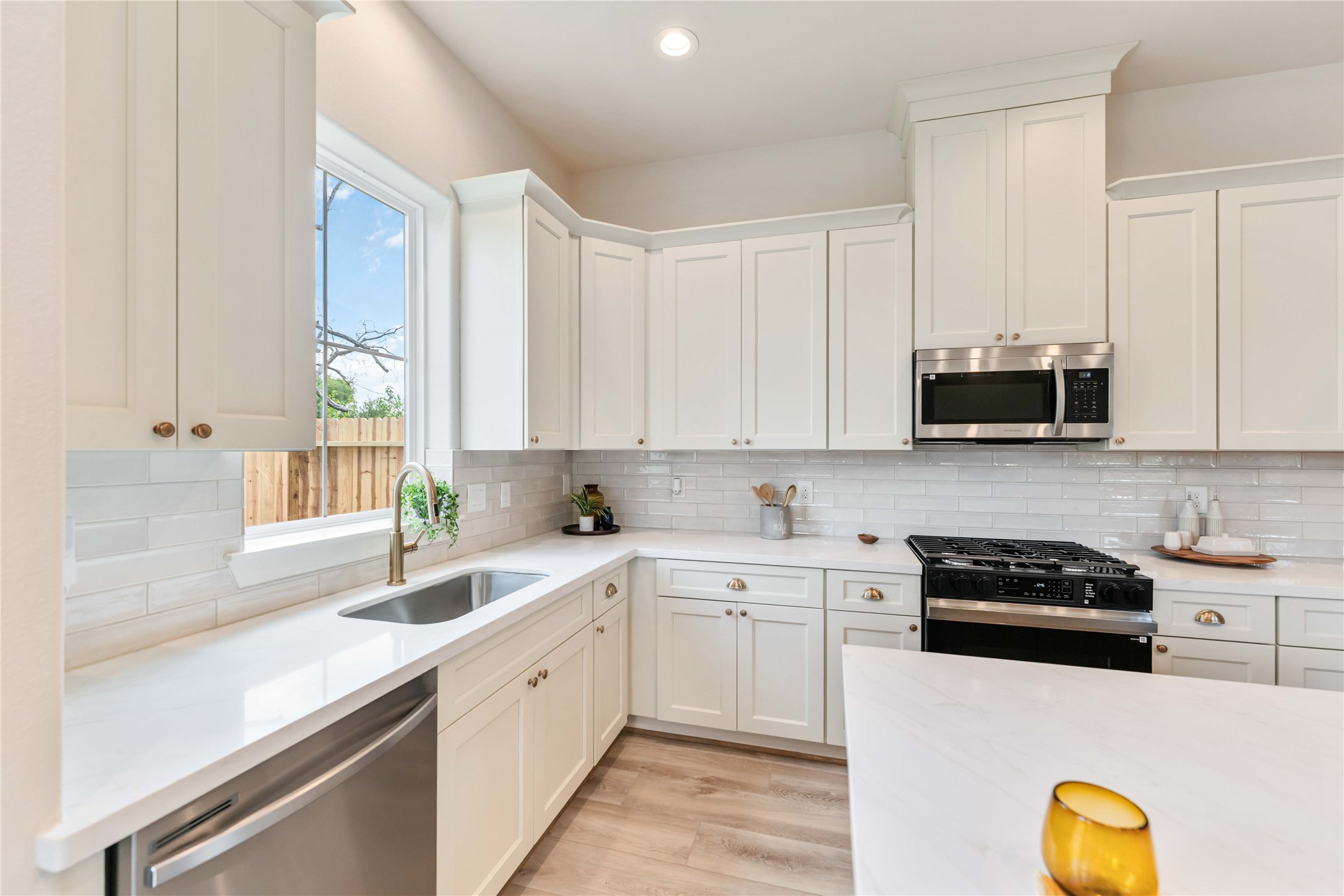 11108 Bauman Road Houston, TX 77076 - Photo 7 of 25 a kitchen with stainless steel appliances granite countertop a sink a stove a microwave and wooden cabinets