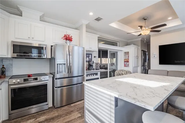 a kitchen with granite countertop a refrigerator stove and microwave