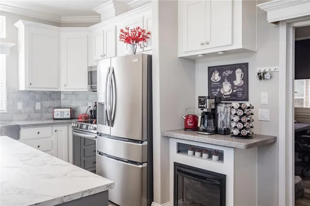 a kitchen with stainless steel appliances granite countertop a refrigerator sink stove and cabinets