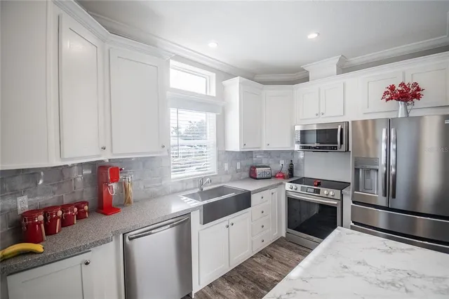 a kitchen with granite countertop a sink stainless steel appliances and cabinets