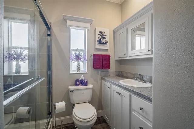 a bathroom with a granite countertop toilet sink and mirror