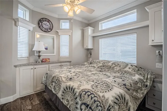 a bed sitting in a bedroom next to a window and a chandelier