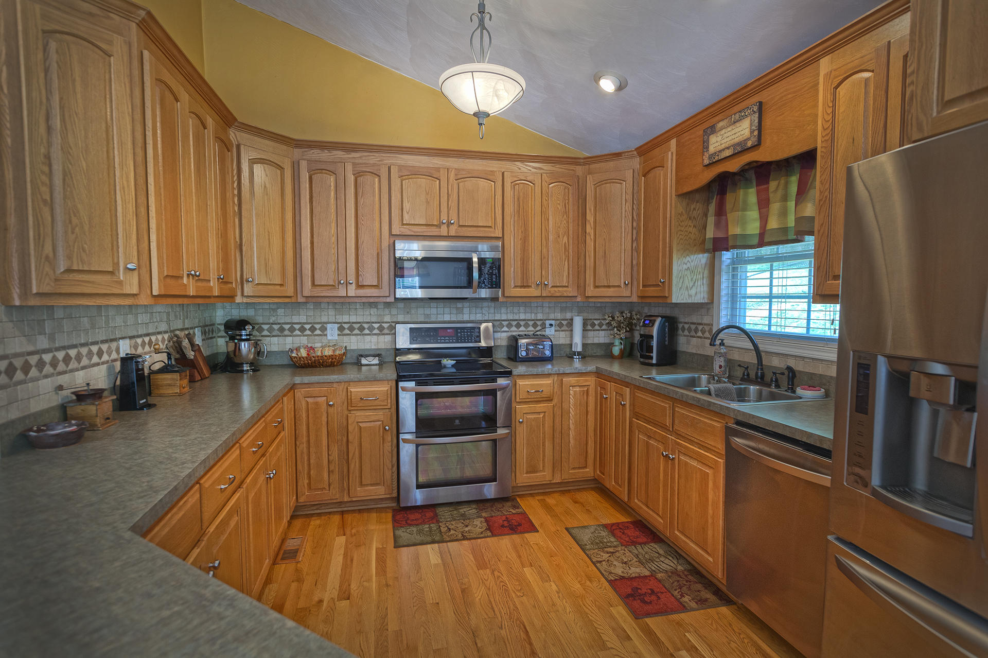 5533 Roanoke Road Troutville, VA 24175 - Photo 12 of 45 a kitchen with stainless steel appliances granite countertop a sink a stove top oven a chimney cabinets and a dining table