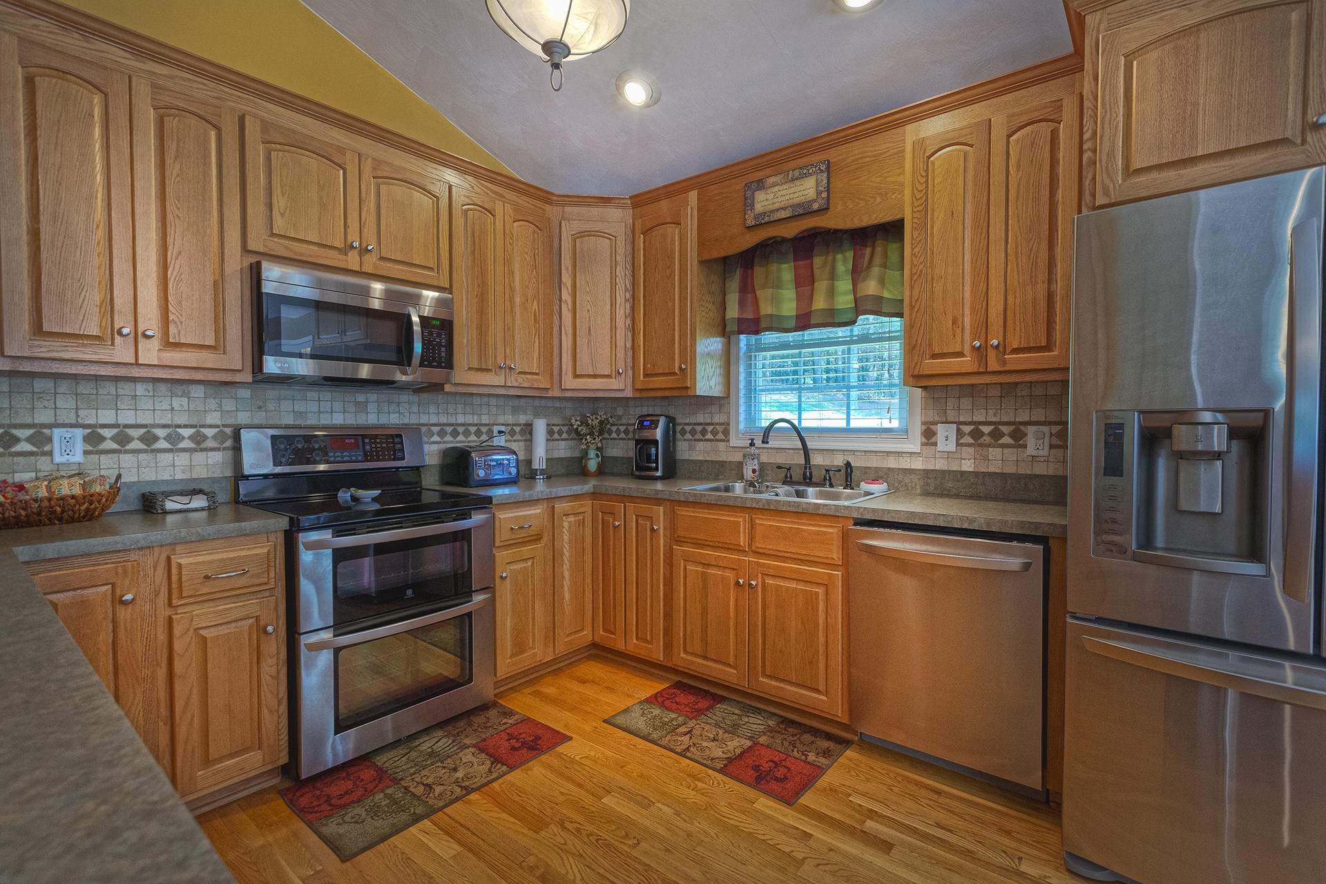 5533 Roanoke Road Troutville, VA 24175 - Photo 13 of 45 a kitchen with stainless steel appliances granite countertop a stove a sink dishwasher a refrigerator and cabinets with wooden floor