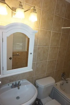 a bathroom with a sink a toilet and shower