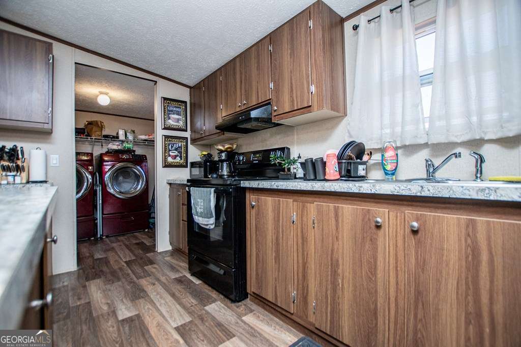 450 Glenloch Road Roopville, GA 30170 - Photo 17 of 60 a kitchen with stainless steel appliances granite countertop a refrigerator a sink dishwasher and wooden cabinets with wooden floor