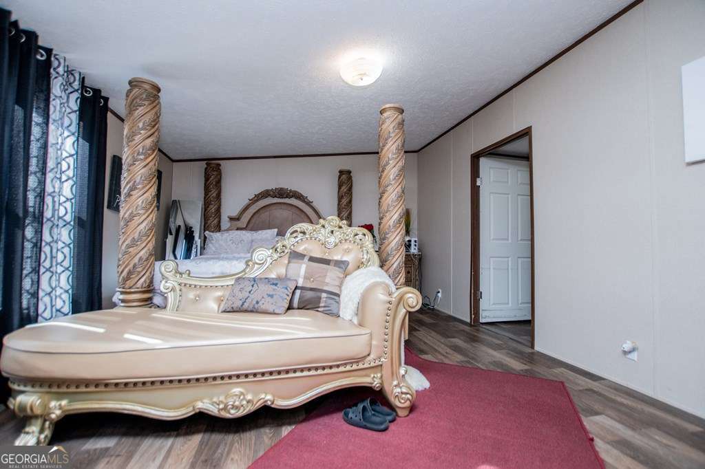 450 Glenloch Road Roopville, GA 30170 - Photo 30 of 60 a bedroom with a bed a mirror and lamp