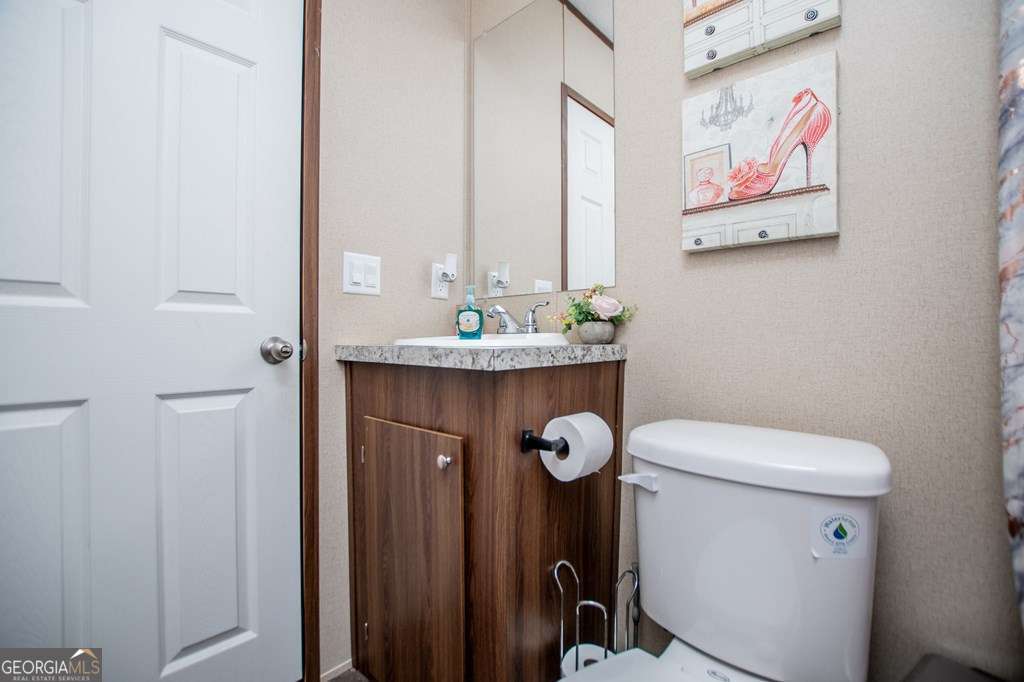 450 Glenloch Road Roopville, GA 30170 - Photo 39 of 60 a bathroom with a toilet a sink and a mirror