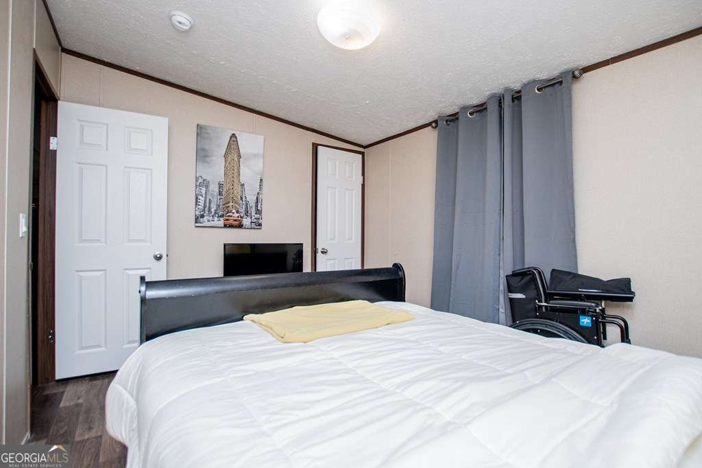 450 Glenloch Road Roopville, GA 30170 - Photo 44 of 60 a bedroom with a bed and a chandelier