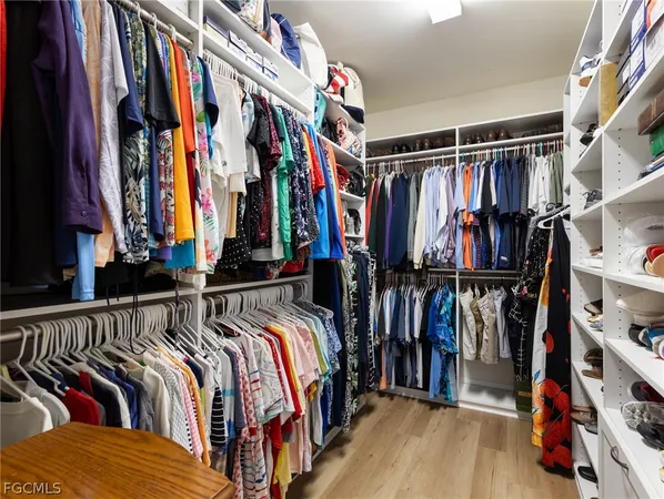 a view of walk in closet with clothes and shoes