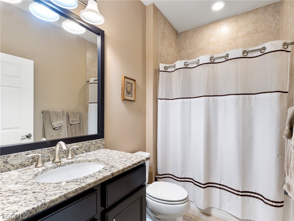 10878 Dennington Road Fort Myers, FL 33913 - Photo 35 of 50 a bathroom with a granite countertop sink toilet and a mirror