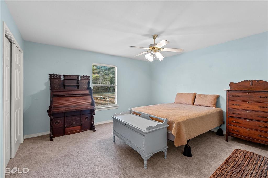 136 Scarborough Road Benton, LA 71006 - Photo 21 of 32 Carpeted room with a ceiling fan, a window with horizontal blinds, and a built-in closet with bi-fold doors