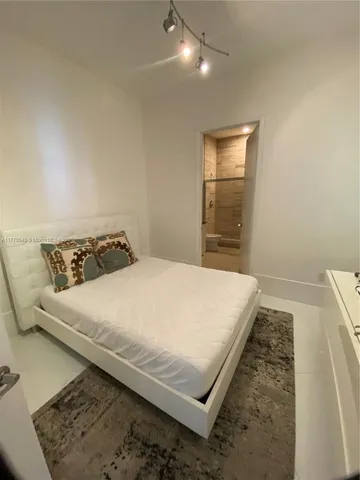 a bedroom with a bed and flat screen tv