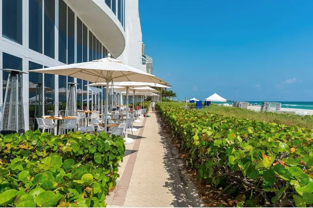 a room with lots of tables a large window and chairs