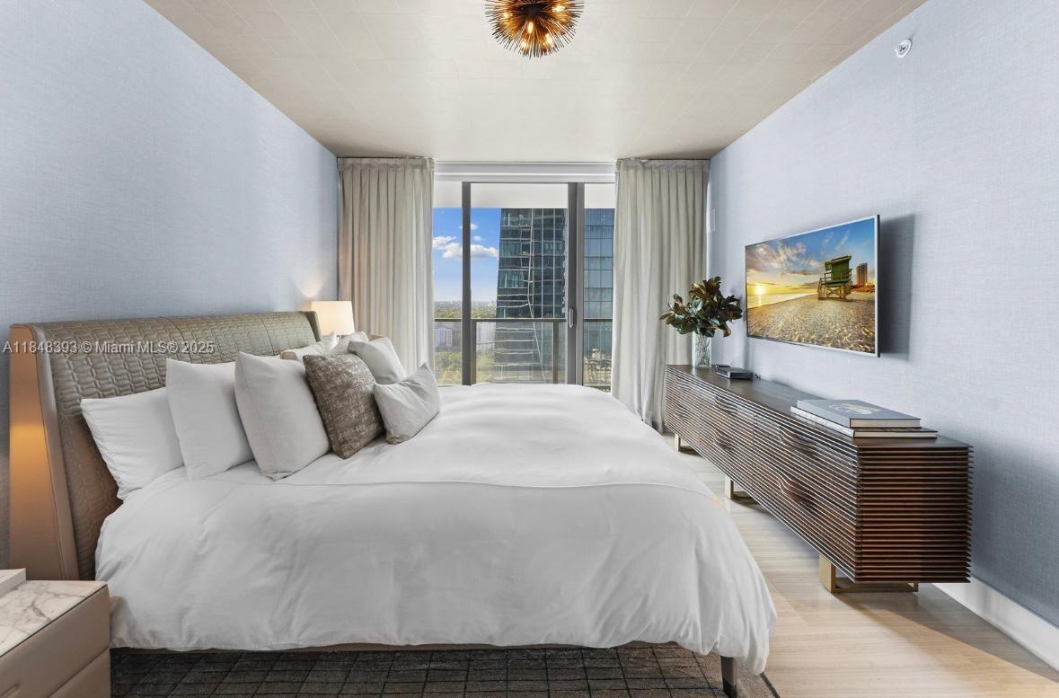1451 Brickell Avenue, Unit 2505 Miami, FL 33131 - Photo 17 of 30 a bedroom with a bed and a flat tv screen on dresser