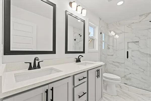 a bathroom with a sink a toilet and a mirror