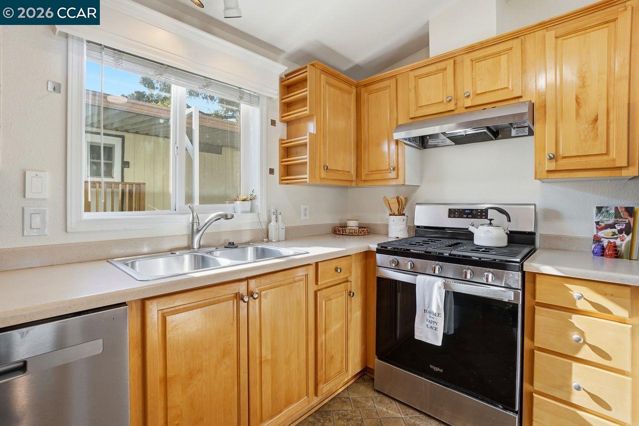3777 Willow Pass Road, Unit 20 Bay Point, CA 94565 - Photo 11 of 35 a kitchen with stainless steel appliances granite countertop a sink stove and cabinets
