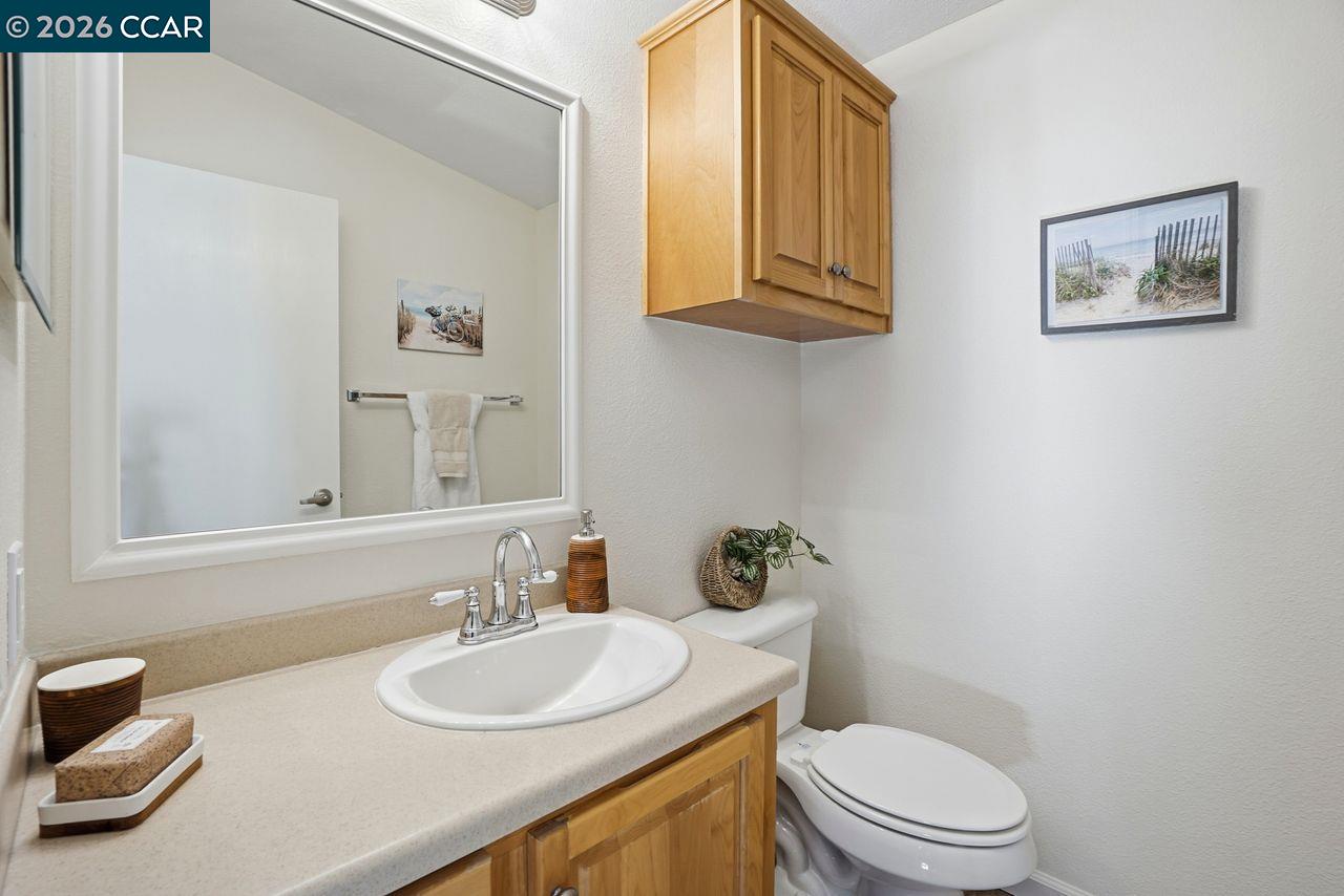 3777 Willow Pass Road, Unit 20 Bay Point, CA 94565 - Photo 24 of 35 a bathroom with a toilet a sink and a mirror