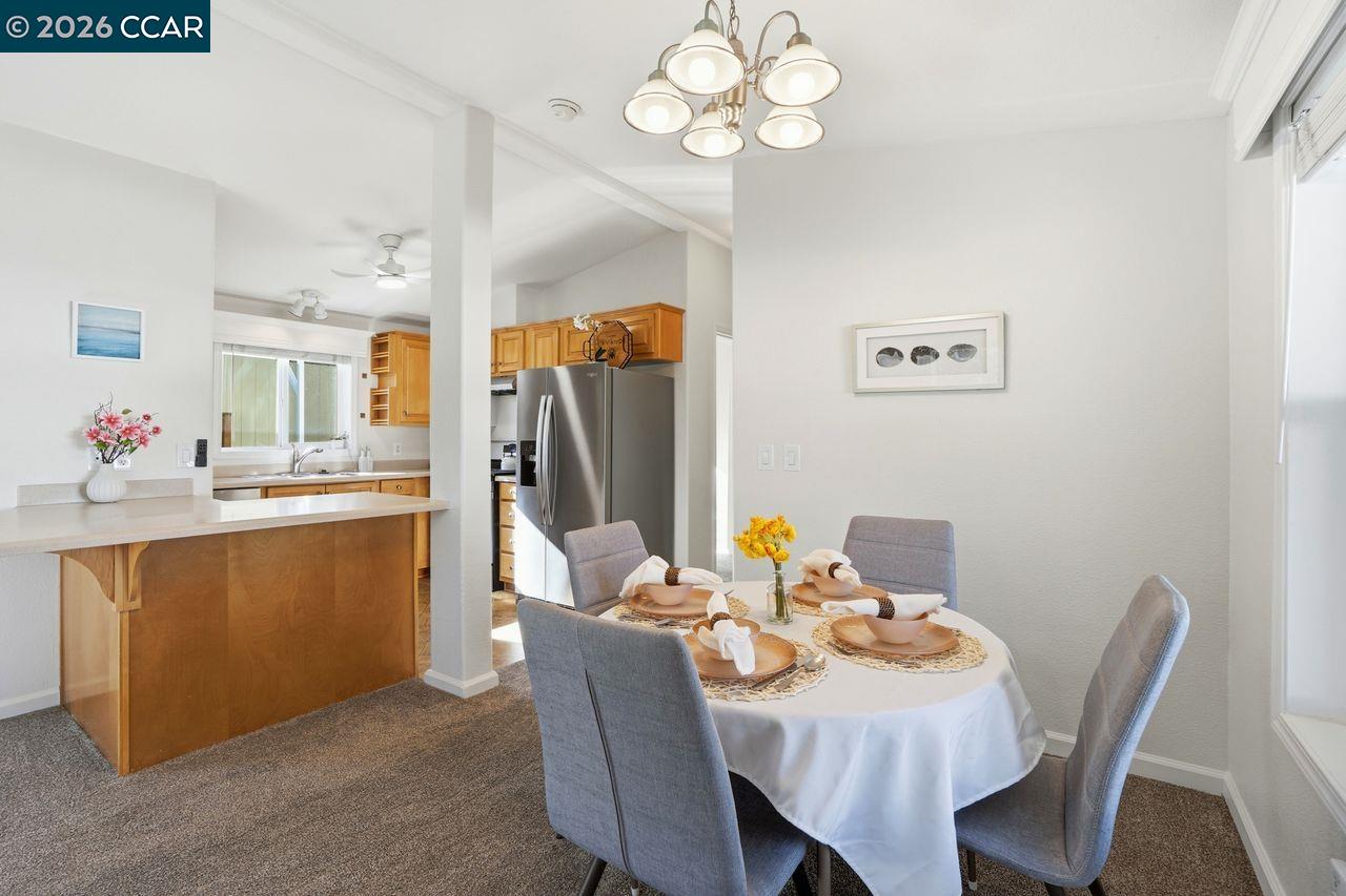 3777 Willow Pass Road, Unit 20 Bay Point, CA 94565 - Photo 9 of 35 a view of a dining room with furniture and a chandelier