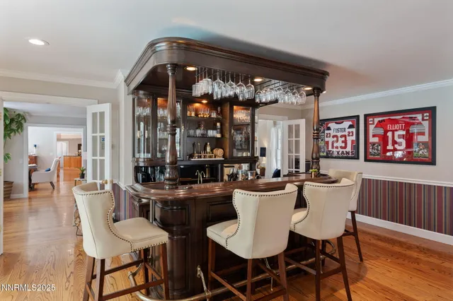 a kitchen with stainless steel appliances granite countertop a refrigerator a sink dishwasher a stove and a dining table with wooden floor