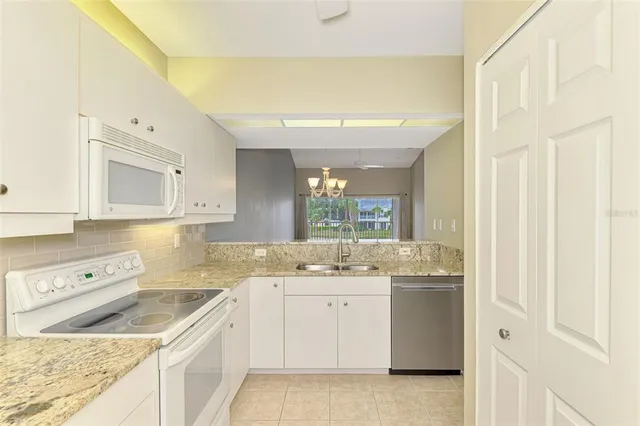 a dining room with wooden floor a chandelier a glass table and chairs