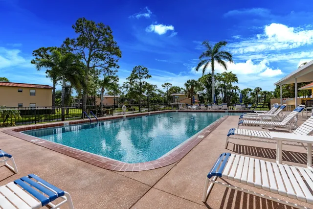 a view of a house with pool and chairs
