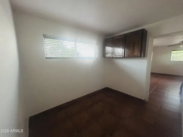 en empty room with windows and ceiling fan