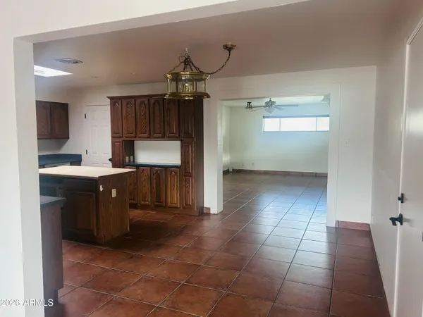 a kitchen with kitchen island granite countertop a sink a counter top space and cabinets