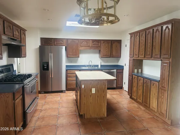 a kitchen with stainless steel appliances granite countertop a refrigerator and a stove top oven