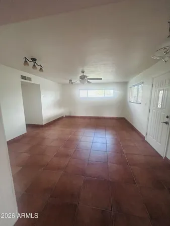 an empty room with a window and a ceiling fan