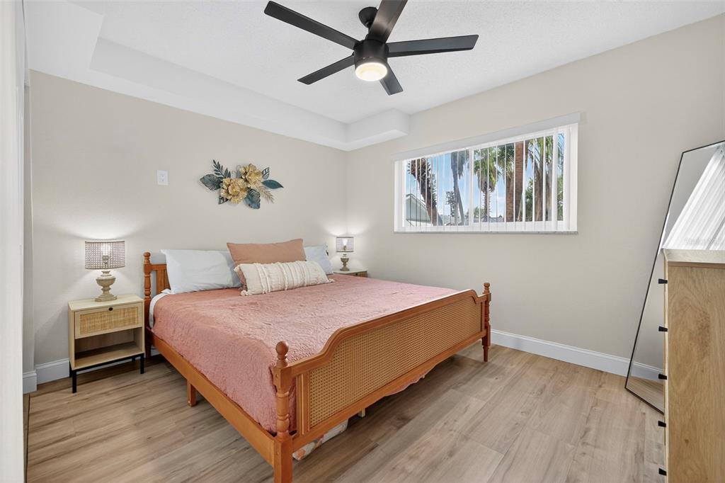 14251 Gulf Boulevard, Unit 5 Madeira Beach, FL 33708 - Photo 11 of 19 a bedroom with a bed and a chandelier