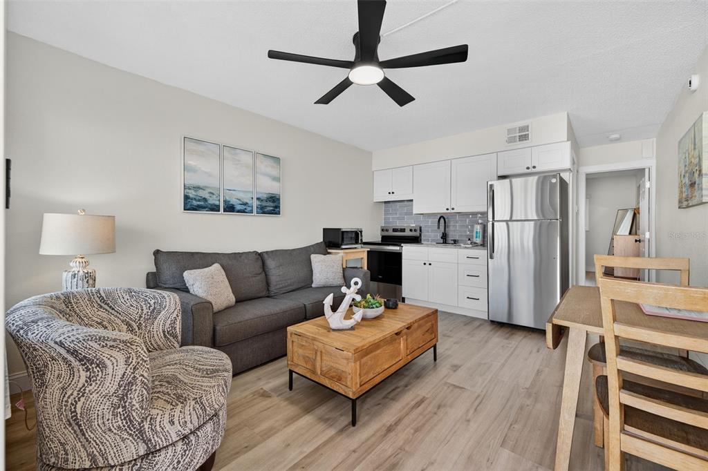 14251 Gulf Boulevard, Unit 5 Madeira Beach, FL 33708 - Photo 5 of 19 a living room with stainless steel appliances furniture and a wooden floor