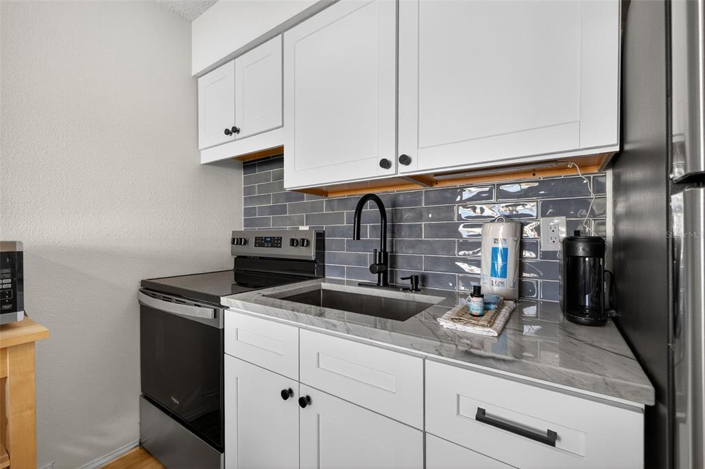 14251 Gulf Boulevard, Unit 5 Madeira Beach, FL 33708 - Photo 10 of 19 a kitchen with appliances cabinets and a counter top space